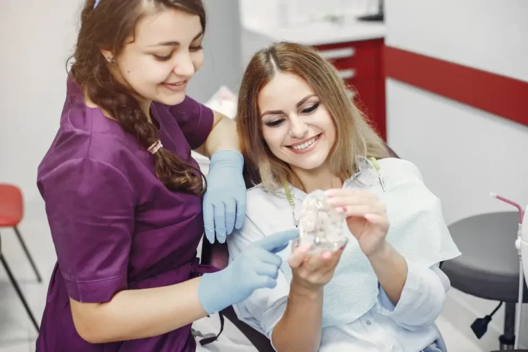 Young woman with a captivating smile sitting in a dentist's office, proudly displaying her customized braces.